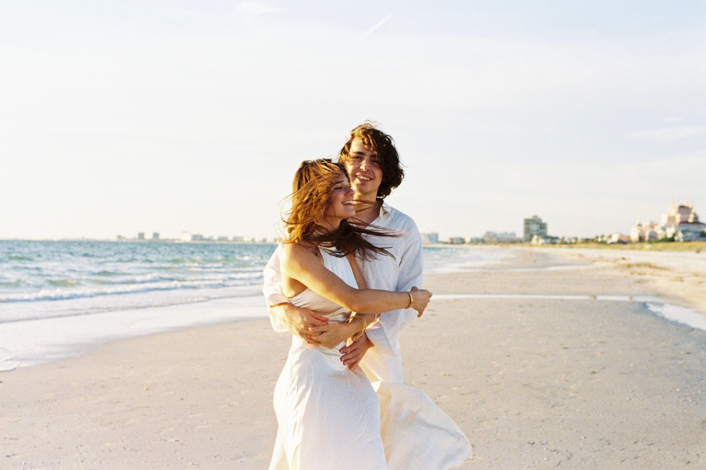 Grace and Christian laughing together on Pass-a-Grille Beach.